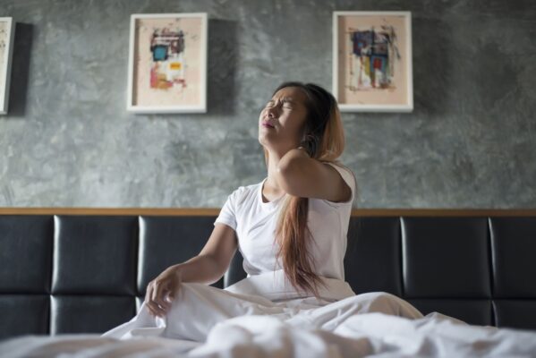 young-woman-sitting-bed-with-neck-pain-after-wake-up